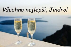 Dvě sklenice šampaňského na pozadí moře s přáním všeho nejlepšího Jindrovi.