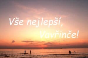 Nápis "Vše nejlepší, Vavřinče!" na pozadí zapadajícího slunce nad mořem se siluetami lidí.