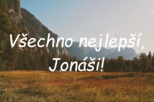 Nápis "Všechno nejlepší, Jonáši!" na pozadí louky obklopené skalami.