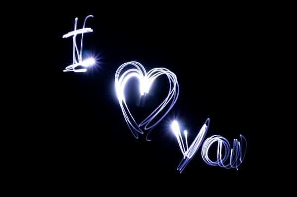 Svítící nápis "I love you" na černém pozadí.